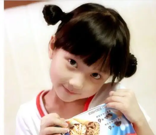 这一位小女孩的两个双低丸子头发型不单扎得很低,同时还扎得很开,这么