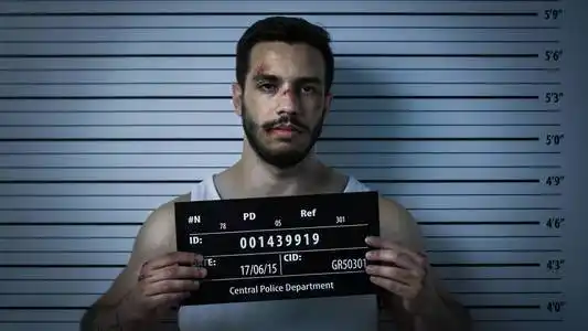 他穿着背心,身上有严重瘀伤,举着标语牌.背景中的身高图表.照片