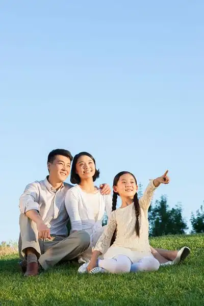 快乐的一家三口坐草地上