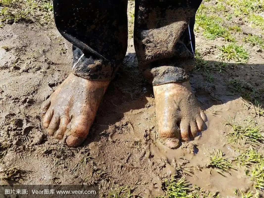 孩子的脚上沾满了泥和草