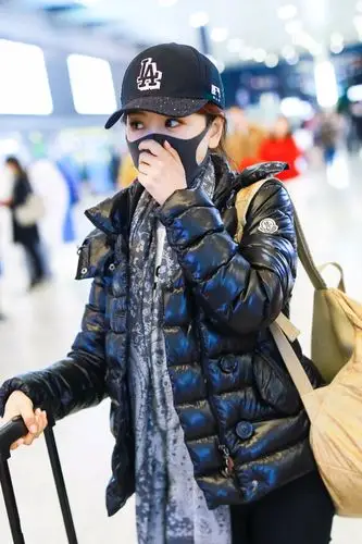 杨蓉穿黑色羽绒服现身机场,戴黑色棒球帽和口罩遮捂严实