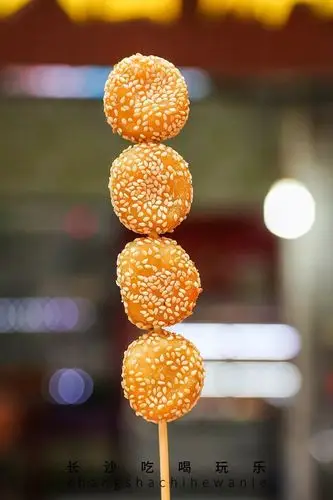 炸至金黄的芝麻球外壳焦脆,内里软糯,表面裹的芝麻颗粒也越嚼越香.