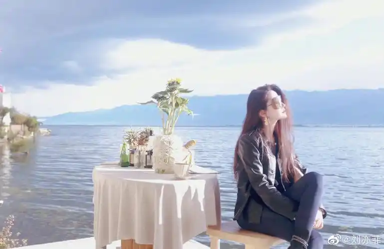 刘亦菲分享出一张逛街回眸背影随拍照,穿着白色大衣戴着棒球帽,自在