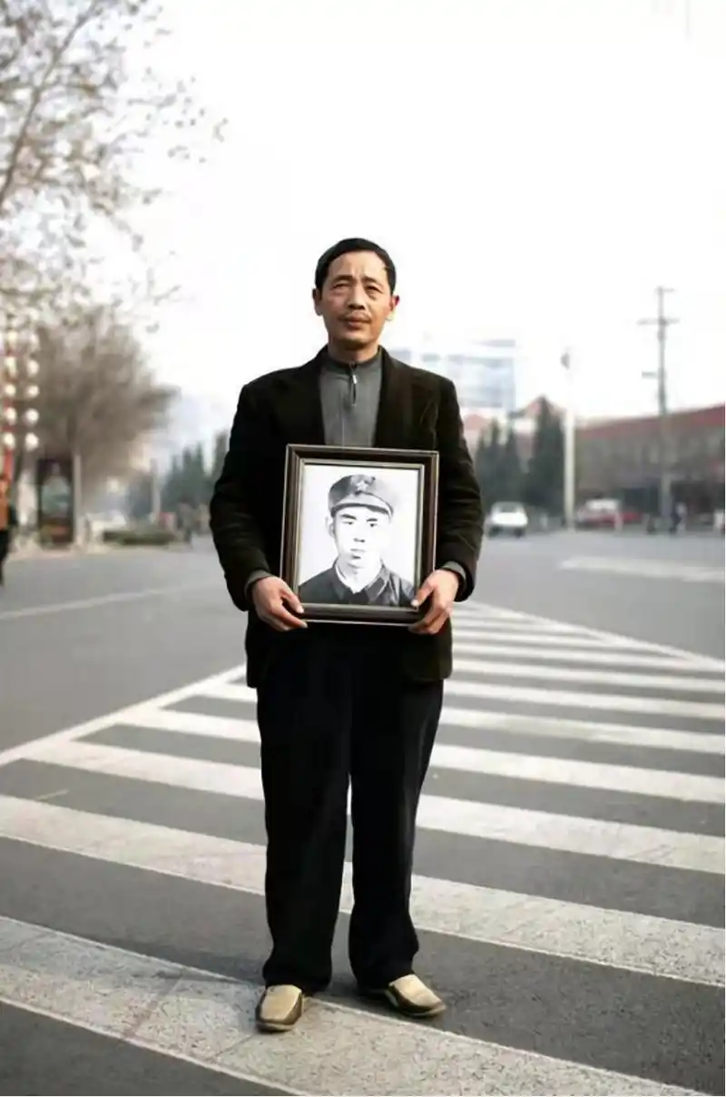 图|郭益民捧着战友遗像