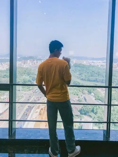 吴磊身穿橘黄色t恤,搭配蓝色牛仔裤,一头短寸头造型干净利落