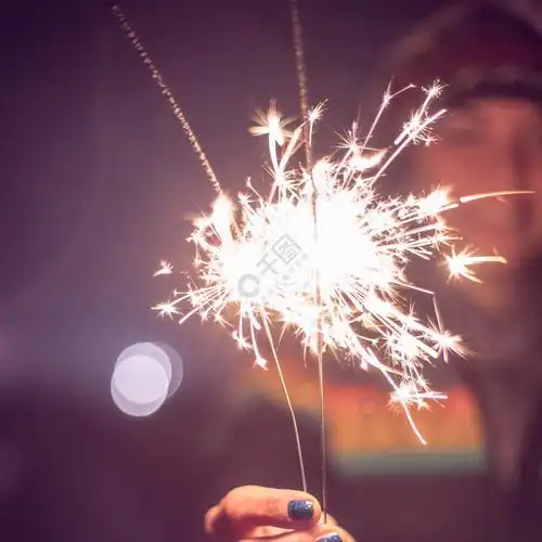 微笑的女孩手里拿着一个烟火新年户外