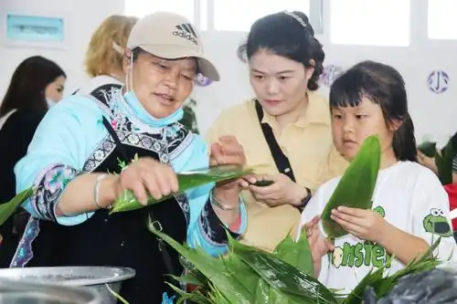 在家委会代表的组织下,部分家长代表与学校师生一起包粽子,让孩子们