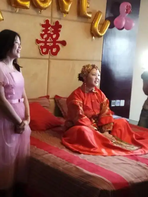 新娘第一次坐在了自己红火喜庆的新床上