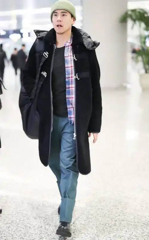 彭于晏低调走机场,黑色系造型简约时尚,躲避镜头不让拍_大衣_运动裤