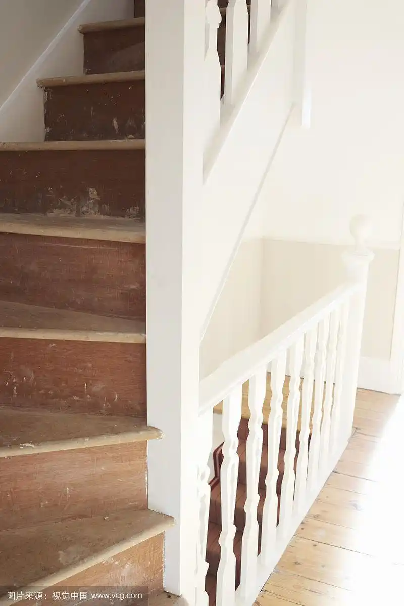 旧木楼梯,有磨损的踏板和白色栏杆