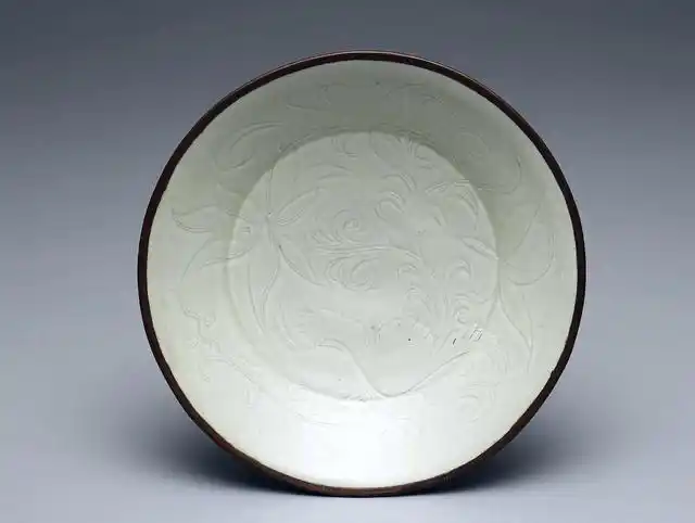 定州白瓷的纹饰和瓷釉特征 定窑的白瓷一直以"白如玉,薄如纸,声如罄"