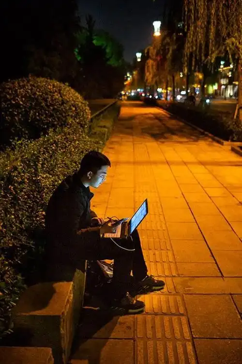 济南夜晚街头办公的小伙