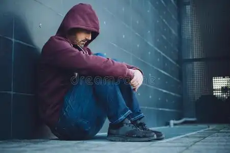 孤独郊区绝望的孤独的人坐着照片