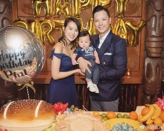 "照片中,胡杏儿和老公李乘德均穿正装出镜,一家三口笑容灿烂看起来