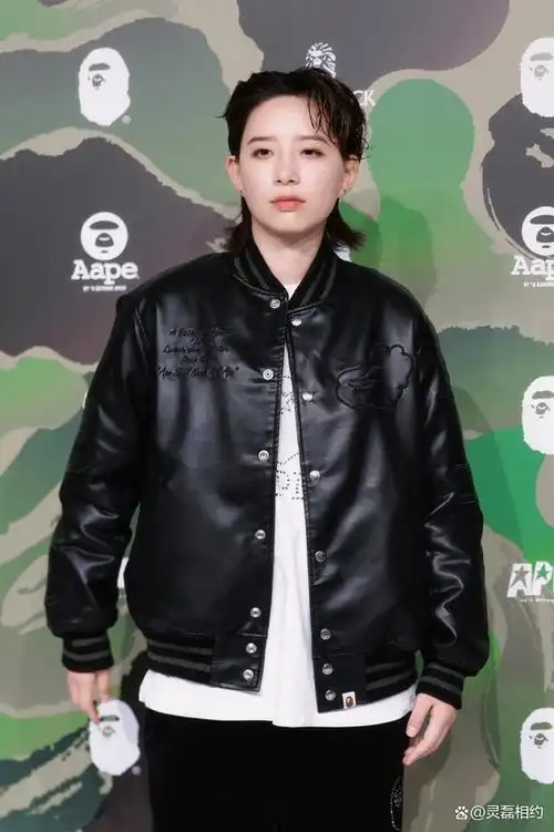 李斯丹妮穿着一件黑色的皮夹克,里面是大白t下面是一条黑色的直筒裤