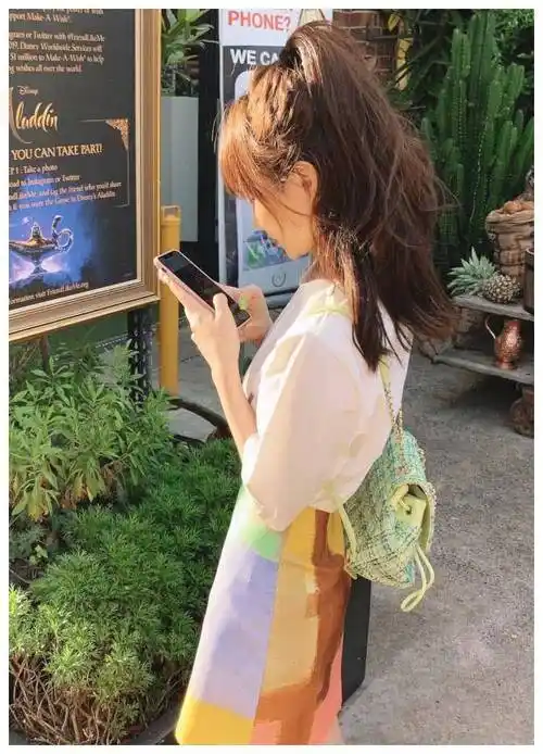 她把头发扎成两半,穿着少女系的衣服,从背影上看像个少女,真美.