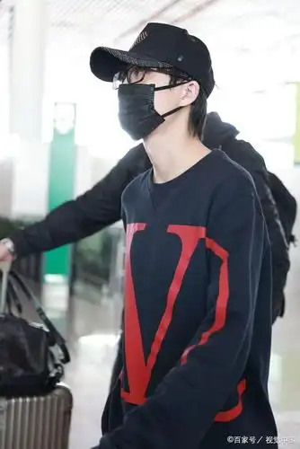 许嵩穿深蓝色卫衣亮相机场 棒球帽上红桃心可爱抢眼