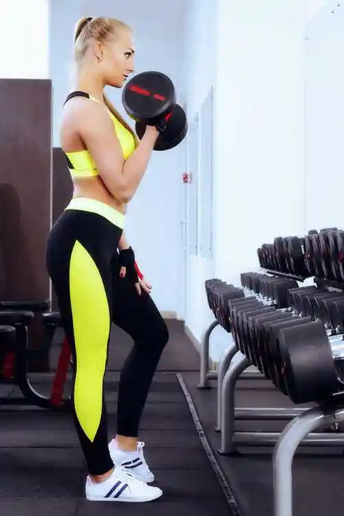 身材苗条的女子在用哑铃健身运动