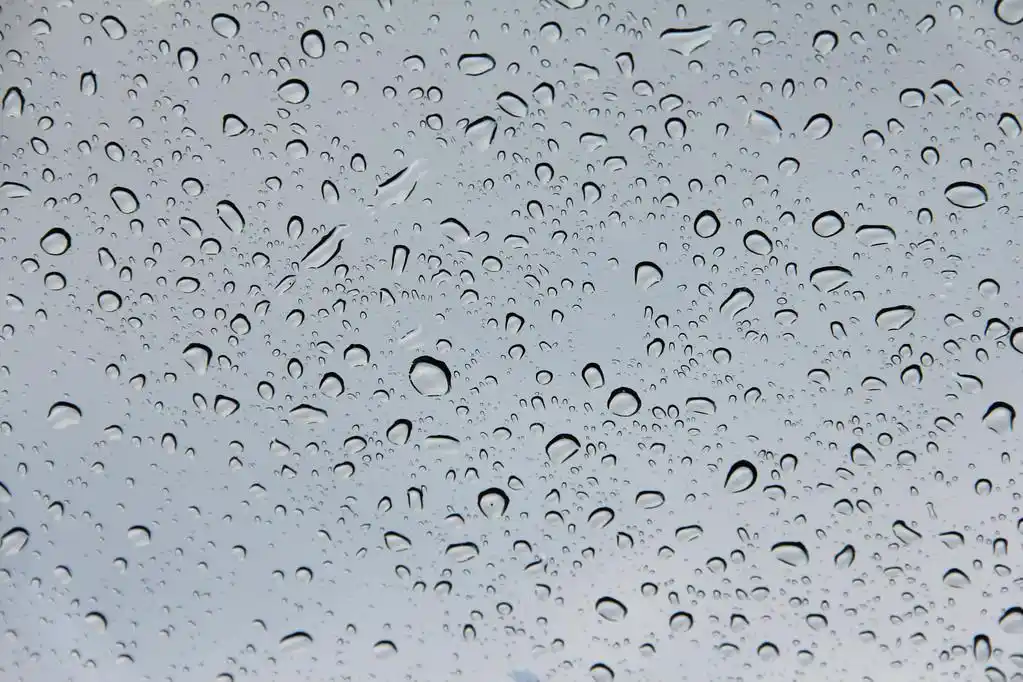 在玻璃上的水珠,水滴透明灰色玻璃上的关闭