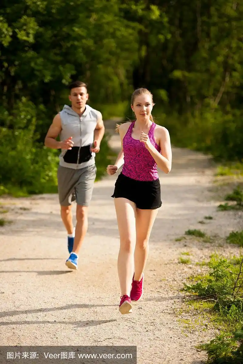 活跃的年轻夫妇在公园里跑步
