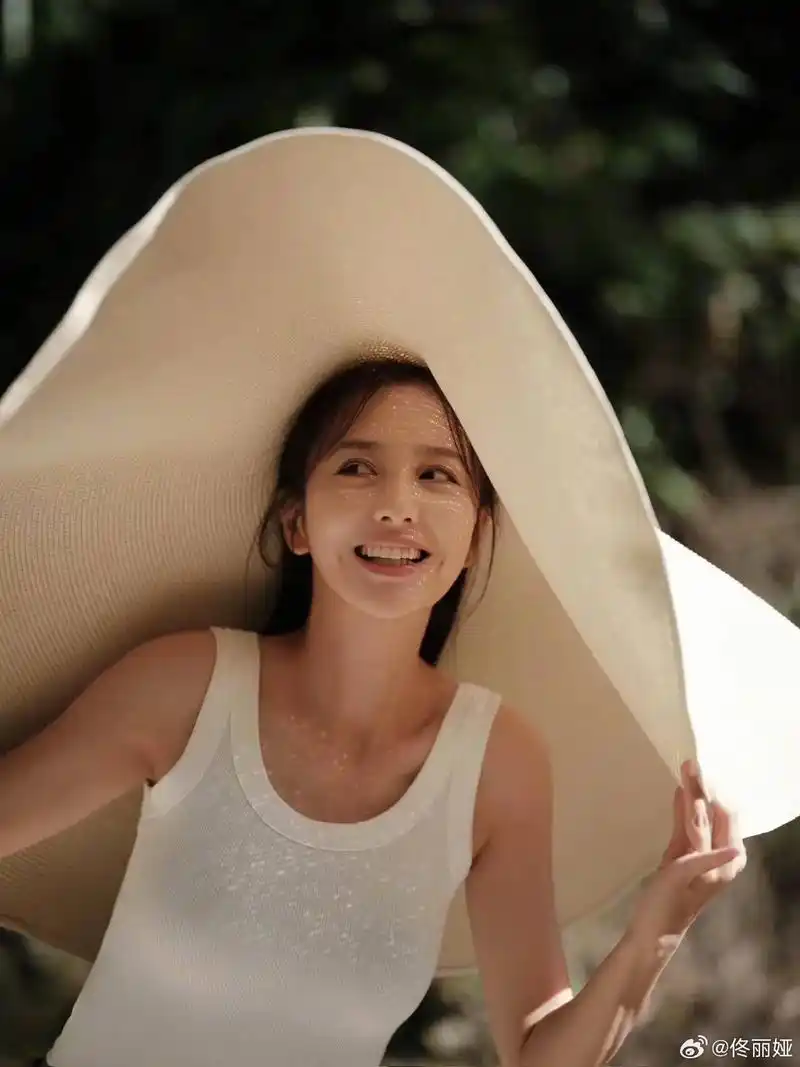 佟丽娅的一组美照曝光,她身穿白色背心头戴超大草帽吸睛十足,笑 - 抖