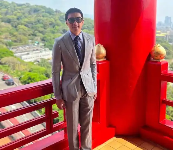 贺军翔一身笔挺的西装,戴着墨镜倚在栏杆上拍照,虽说是"人逢喜事"