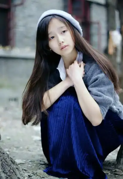 戴着浅蓝帽子,长发披肩,歪头微笑,蓝色上衣白衣领的女生图片,如下图