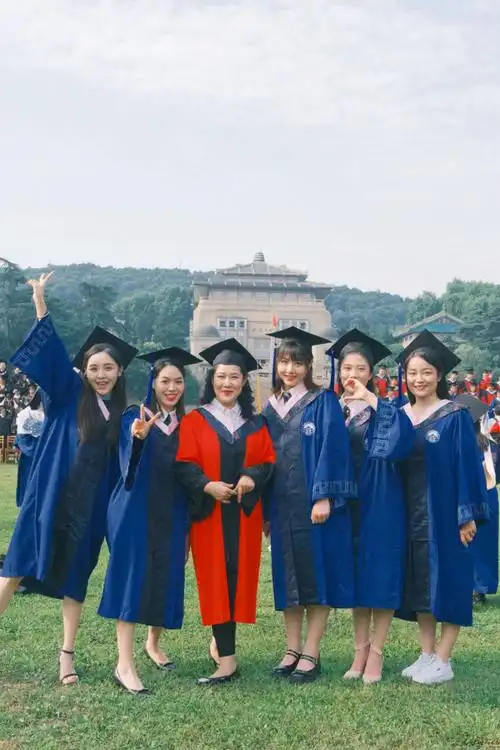 生们穿着学士服,在行政楼前的操场上,留下他们人生中重要的毕业合影