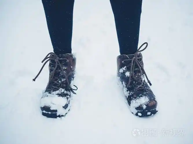 站在外面雪地里的年轻女子的脚