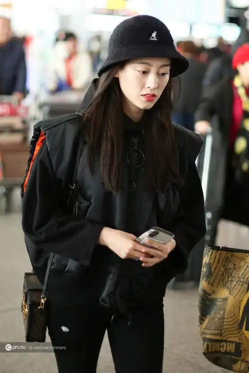 街拍祝绪丹黑色卫衣羽绒背心紧身裤渔夫帽街头个性