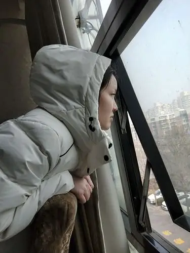 孩子望着窗外,渴望自由的眼神很无奈.