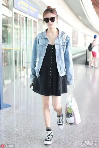 徐璐嘴叼棒棒糖现身机场 对镜头甜笑十分少女