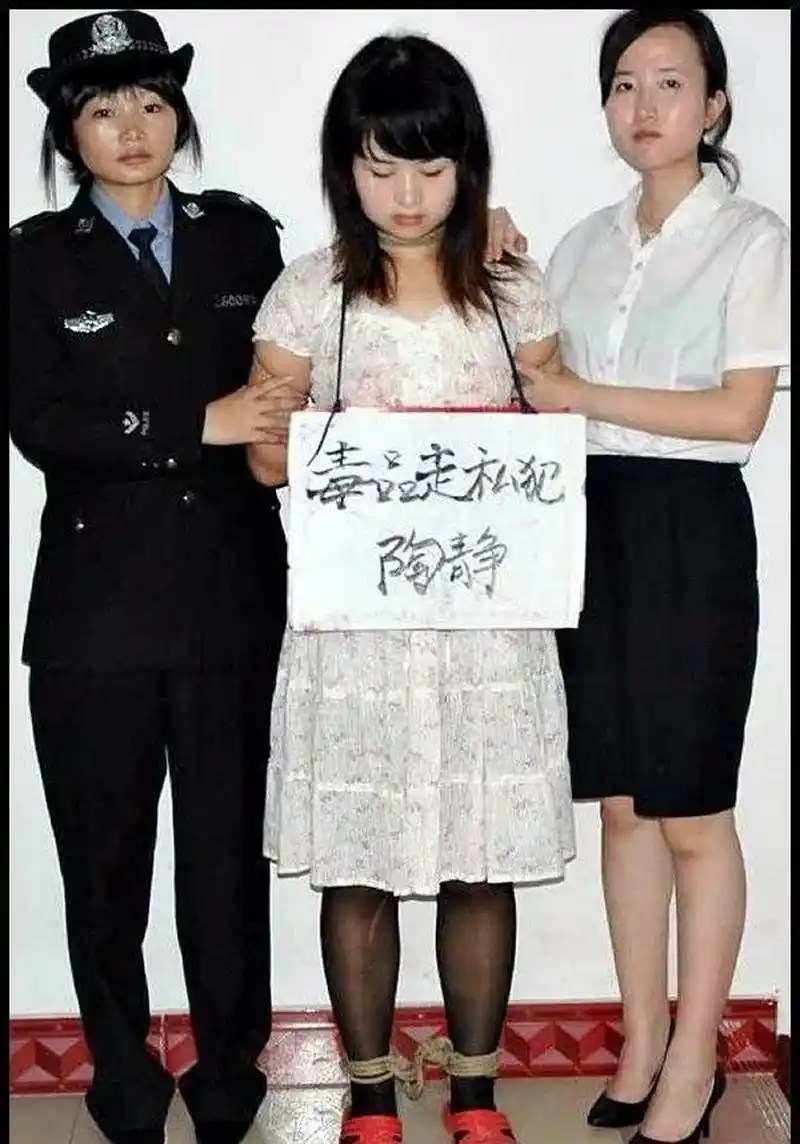 但她身后的两个工作人员,看气质却有点违和,因此推断这个照片不是真