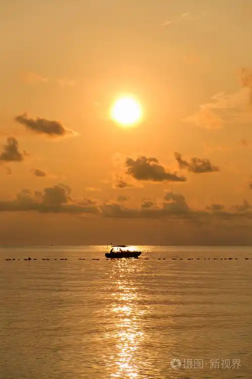 海上日出时用的小船的轮廓的海景