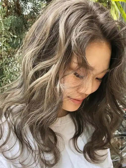 比起一般的棕色系染发,"奶茶色"会将明度再提高,打造出阳光下头发自然