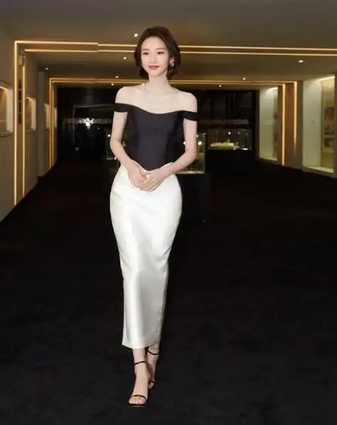 从照片上我们可以看到,唐艺昕穿了一袭花苞裙,脚踩一双黑色高跟凉鞋