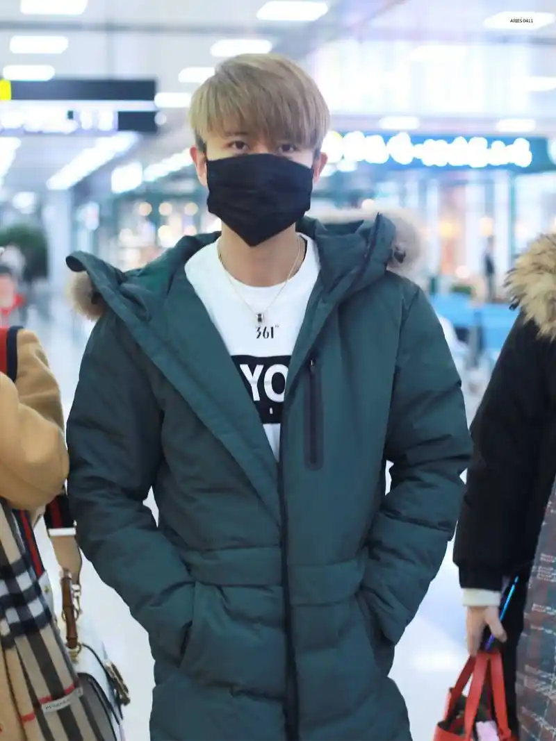 任嘉伦戴口罩穿黑色羽绒服现身机场,手捧鲜花.