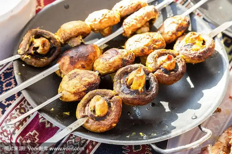 烤开胃蘑菇上的金属串