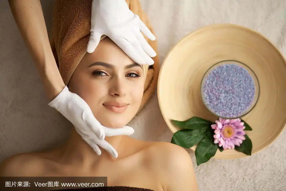 水疗中心.美丽的年轻女子正在美容院做面部护理