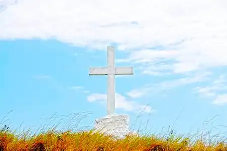 架在山和蓝色天空在日落天空木制的基督教木十字架彩色云与镜头耀斑