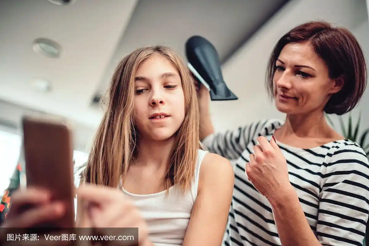 母亲在给女儿吹头发