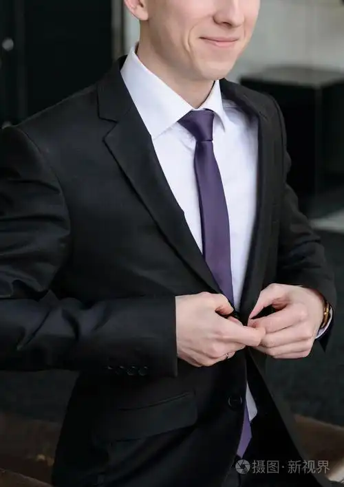 穿着一件白衬衫和黑色西装的男人