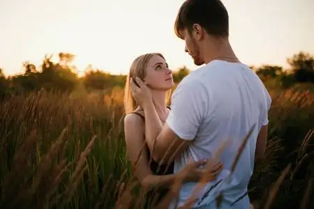 在日出或日落时相爱的两人.男人和女人对场照片