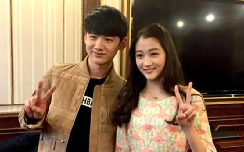 白敬亭和关晓彤一起合影,两人都面带微笑看向镜头,画风很是和谐.