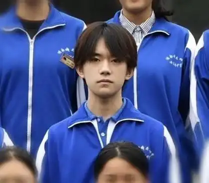 易烊千玺站在同学中间,相当亮眼,梳了一头中分,五官和颜值超