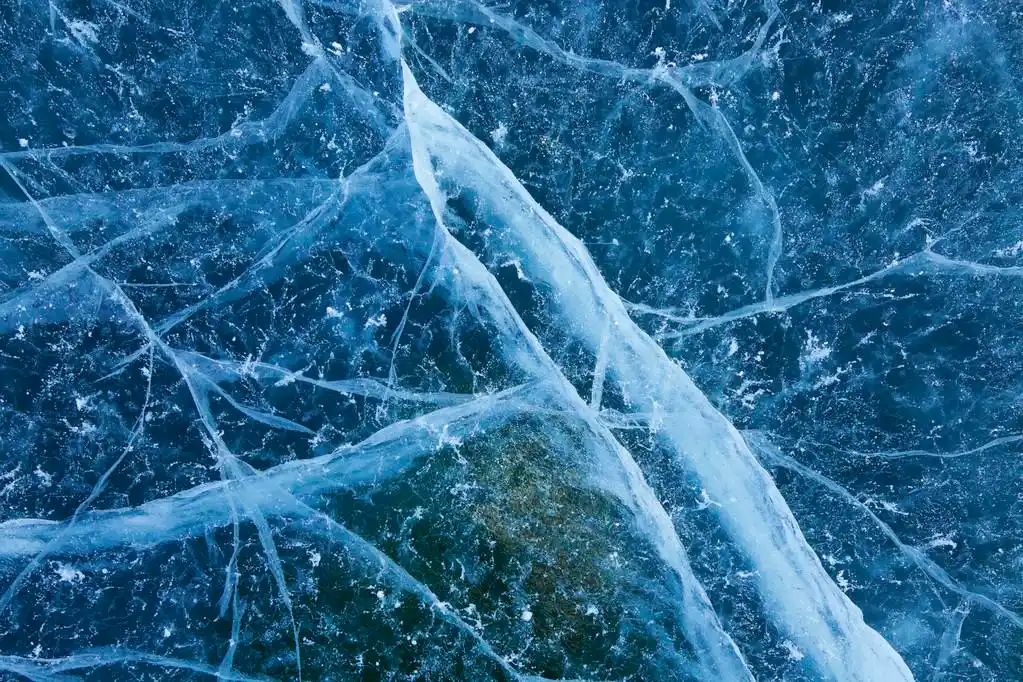 蓝色碎的冰背景,蓝色冰裂纹和损害背景纹理.