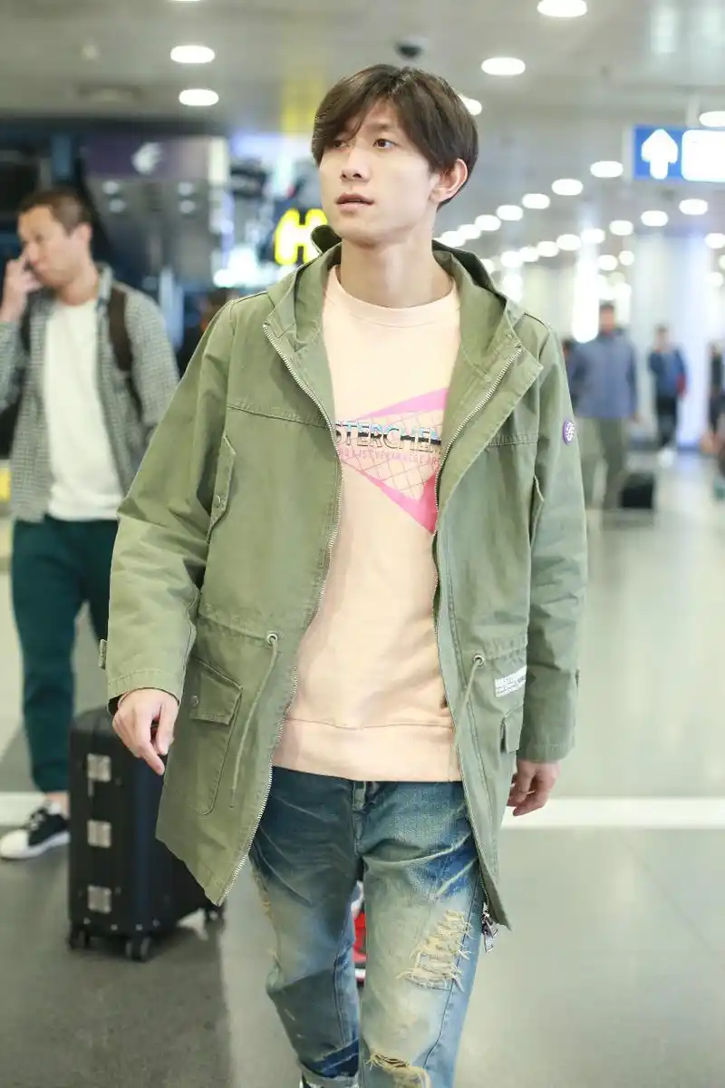 张一山穿军绿色外套搭配牛仔裤现身机场,头发刘海太长都遮眼睛了