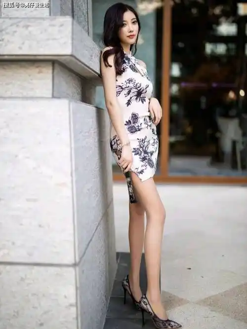 在一张模糊而充满艺术感的照片中,一位身着黑白花卉旗袍的女性模特,以