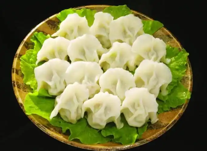 有的农家,把捏成弯月形的饺子两角对拉捏在一起,呈"元宝"形,摆在盖