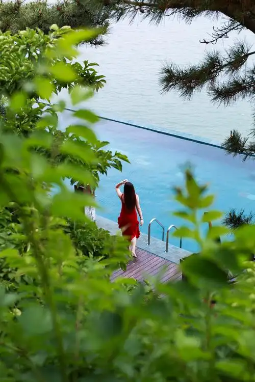 海边拍照欣赏风景的红衣美女高角度视角